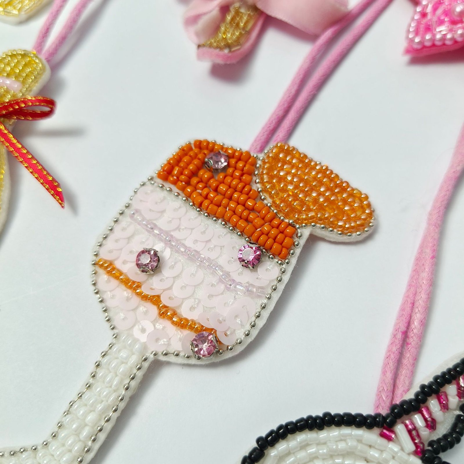 Handmade beaded embroidery applique ice cream design with orange and white beads for DIY crafts