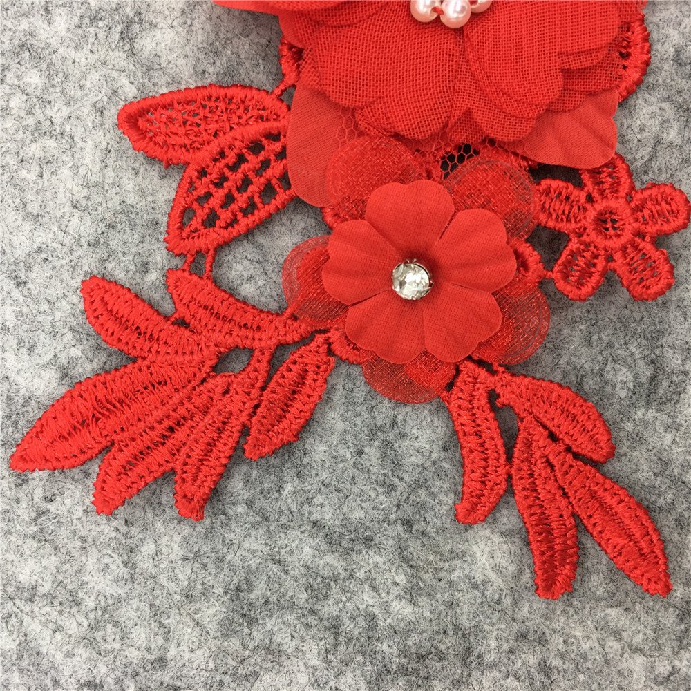 Close-up of red 3D floral embroidery applique lace patch with beaded pearl center for DIY sewing