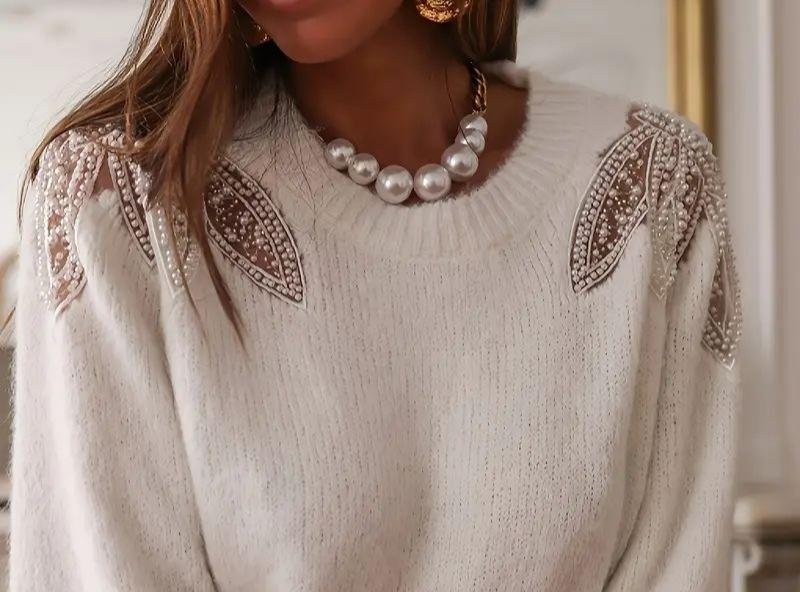 Beaded applique applied on the shoulder of a knit sweater, highlighting garment decoration and shoulder detail design