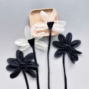 Black and white fabric flower appliqués with layered petals for garment decoration