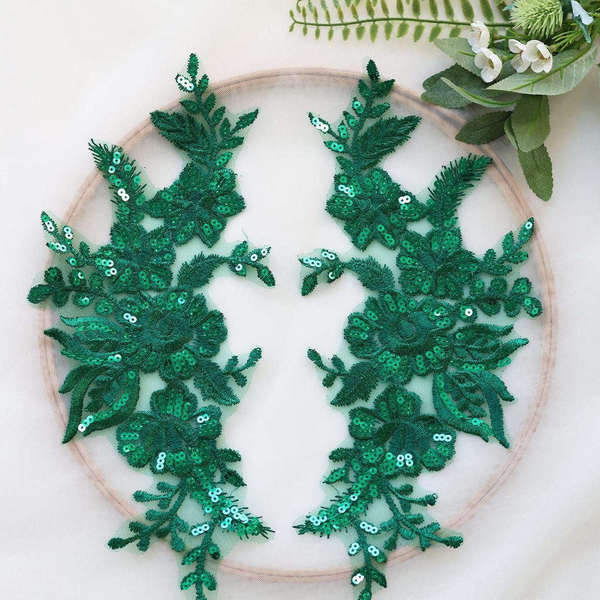 Green sequin embroidered floral appliqué pair with leaf motifs on soft mesh base